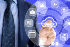 An expert in a blue suit is pressing a glowing cloud symbol with saas, software as a service and icons of services around.