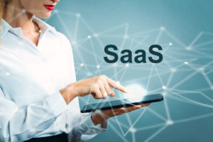 SaaS text with business woman using a tablet