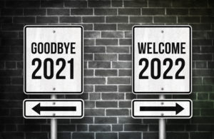 This is a picture of street signs that say "Goodbye 2021" and "Welcome 2022"