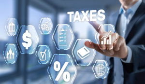 someone points to the word taxes, underneath are bubbles with different tax-themed images such as a percent sign, check box, globe and more.