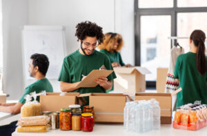 Smiling male volunteer packs up boxes for a nonprofit. 